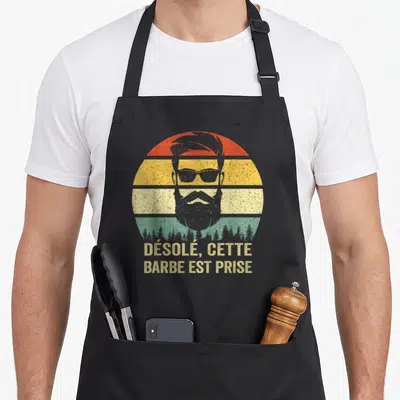 Tablier de cuisine noir avec illustration d'un homme barbu aux lunettes de soleil et texte désolé cette barbe est prise.