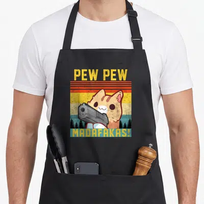 Tablier de cuisine noir avec illustration vintage d'un chat tenant un pistolet et le texte Pew Pew Madafakas en lettres jaunes.