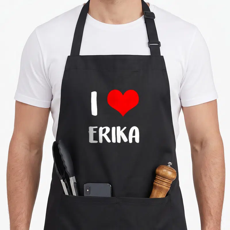 Tablier de cuisine noir avec inscription blanche J'adore Erika et un grand cœur rouge au centre du motif imprimé.