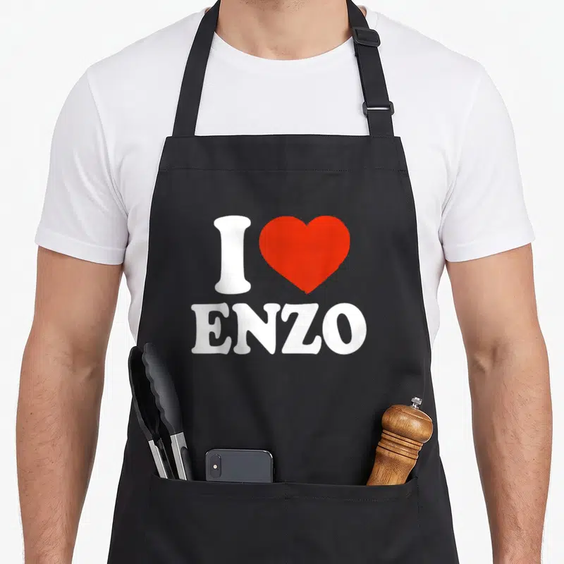 Tablier de cuisine noir avec l'inscription blanche I Heart Enzo surmontée d'un grand cœur rouge vif au centre.