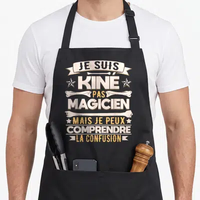 Tablier de cuisine noir avec l'inscription Je suis Kine pas magicien mais je peux comprendre la confusion entourée d'os et d'étoiles.