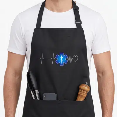 Tablier de cuisine noir avec étoile de vie bleue, électrocardiogramme blanc et cœur stylisé imprimé au centre.