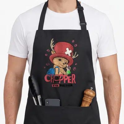 Tablier de cuisine noir avec illustration colorée du docteur Chopper tenant un flacon de potion verte.