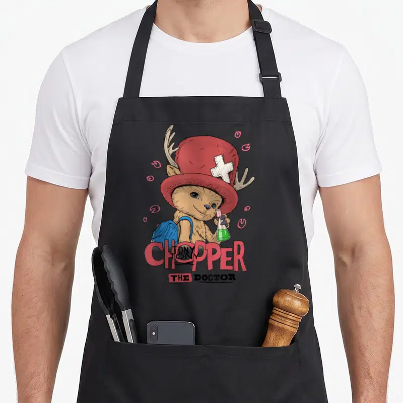 Tablier de cuisine noir avec illustration colorée du docteur Chopper tenant un flacon de potion verte.