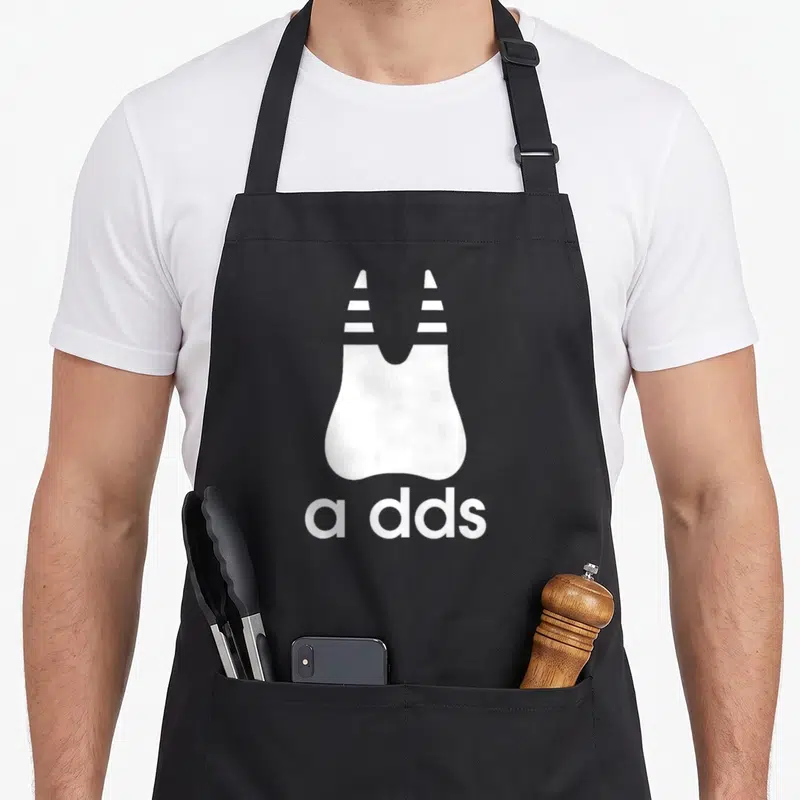 Tablier de cuisine noir avec illustration blanche d'une dent stylisée et le texte a dds imprimé en bas.