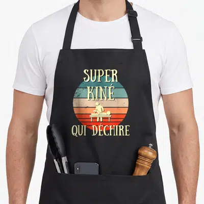 Tablier de cuisine noir avec un motif circulaire retro et une silhouette de kinéso sur table de massage.