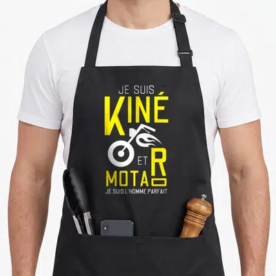 Tablier de cuisine noir avec l'inscription Je suis Kiné et Motard et un dessin de moto stylisée en blanc et jaune vif.