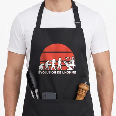 Tablier de cuisine noir avec illustration blanche de l'évolution humaine terminant par un dentiste devant un soleil rouge.