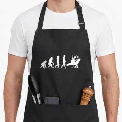 Tablier de cuisine noir avec silhouette blanche représentant l'évolution humaine jusqu'au dentiste au fauteuil.