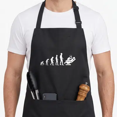 Tablier de cuisine noir avec silhouette blanche représentant l'évolution humaine vers un dentiste au fauteuil.