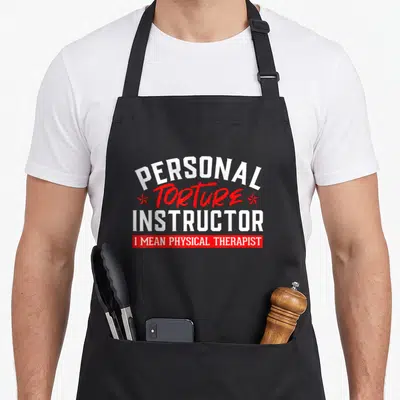 Tablier de cuisine noir avec l'inscription Personal Torture Instructor en blanc et rouge.