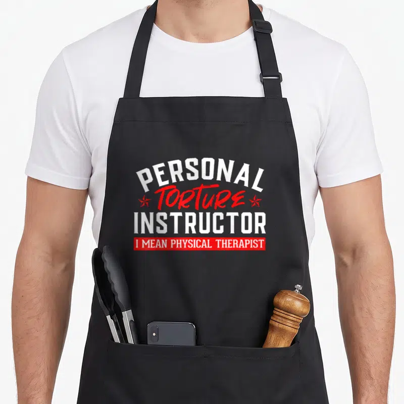 Tablier de cuisine noir avec l'inscription Personal Torture Instructor en blanc et rouge.