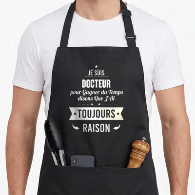 Tablier de cuisine noir avec l'inscription Je suis docteur pour gagner du temps disons que j'ai toujours raison en typographie blanche et crème.