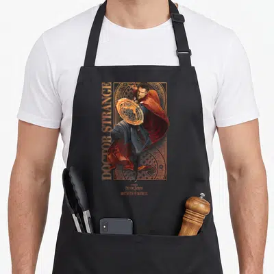 Tablier de cuisine noir avec illustration du Docteur Strange tenant un cercle magique doré et son cape rouge flottante.