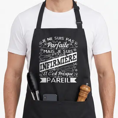 Tablier de cuisine noir avec inscription blanche humoristique infirmière entourée de stéthoscope et fleurs.