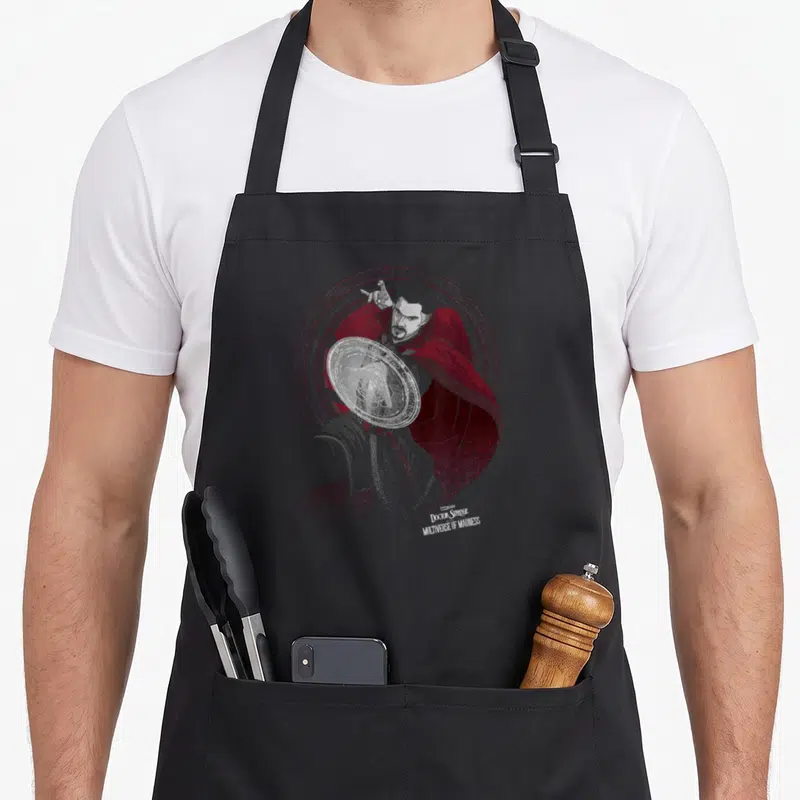 Tablier de cuisine noir avec illustration du Docteur Strange et ses portails dimensionnels rouges et blancs.