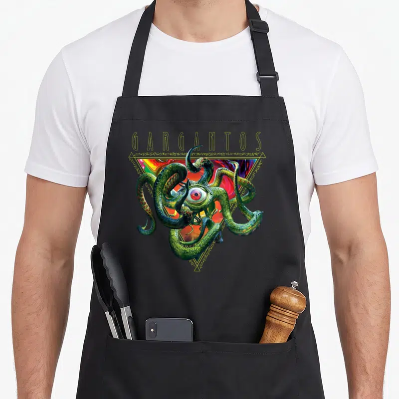 Tablier de cuisine noir avec illustration du monstre Gargantos aux tentacules verts et un grand œil central.