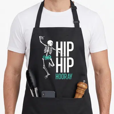 Tablier de cuisine noir avec squelette blanc dansant et texte Hip Hip Hooray turquoise.