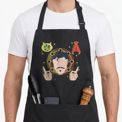 Tablier de cuisine noir avec illustration stylisée de Doctor Strange, l'Eye Agamotto et une cape rouge flottante.