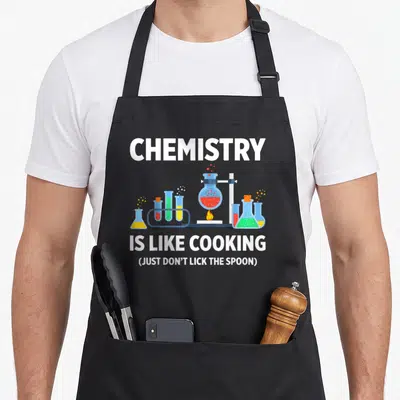 Tablier de cuisine noir avec illustration de flacons de chimie colorés et texte blanc sur fond gris.