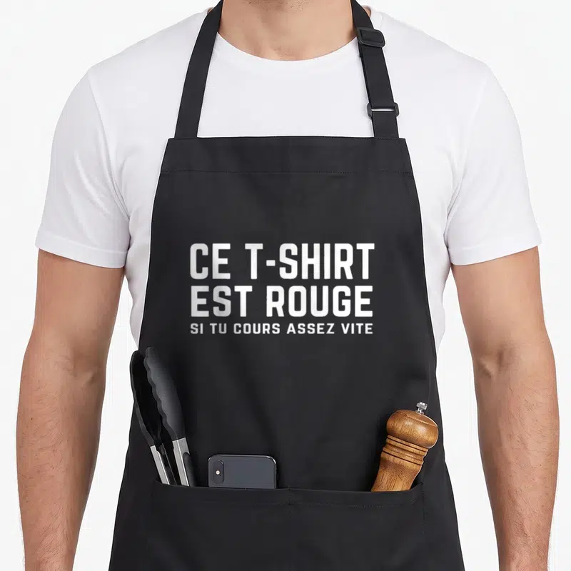 Tablier de cuisine noir avec le texte blanc ce vêtement est rouge si tu cours assez vite imprimé au centre.