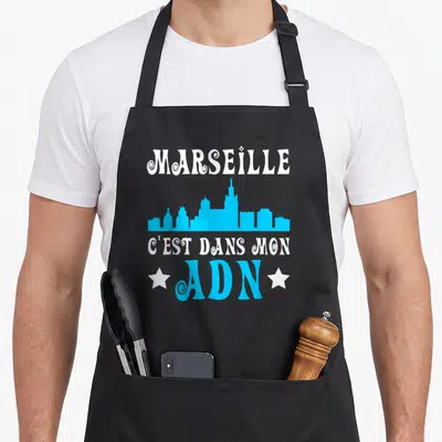 Tablier de cuisine noir avec skyline bleu et texte blanc Marseille c'est dans mon ADN ADN encadré d'étoiles blanches