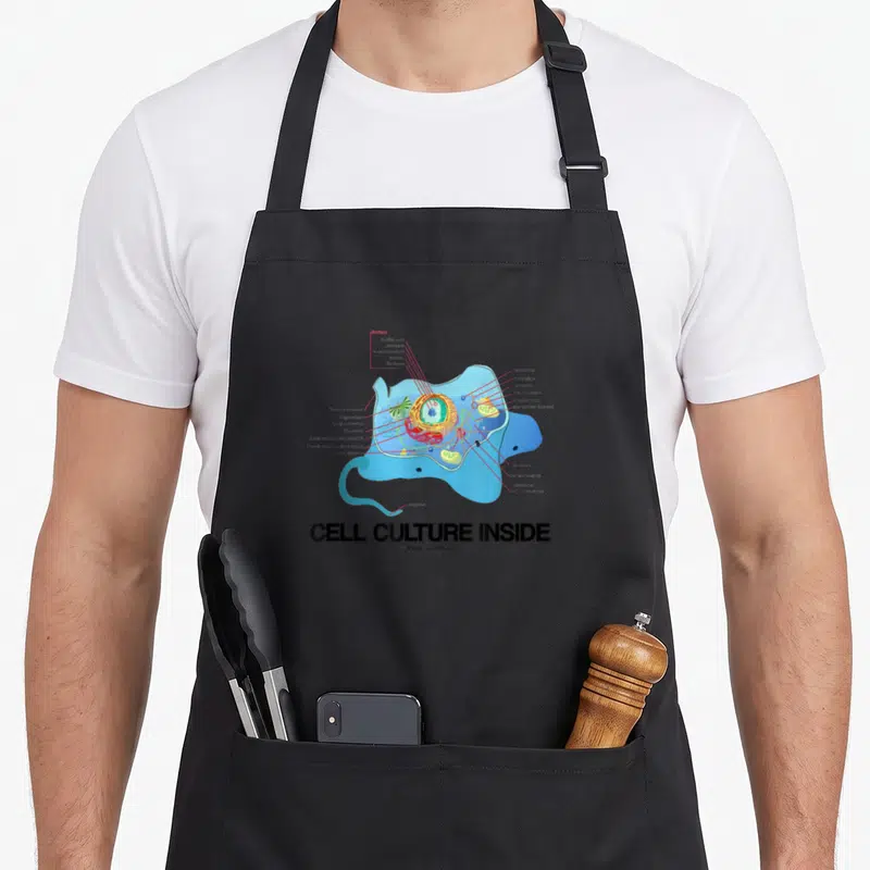 Tablier de cuisine noir avec illustration colorée d'une cellule eucaryote et le texte Cell Culture Inside en bas.