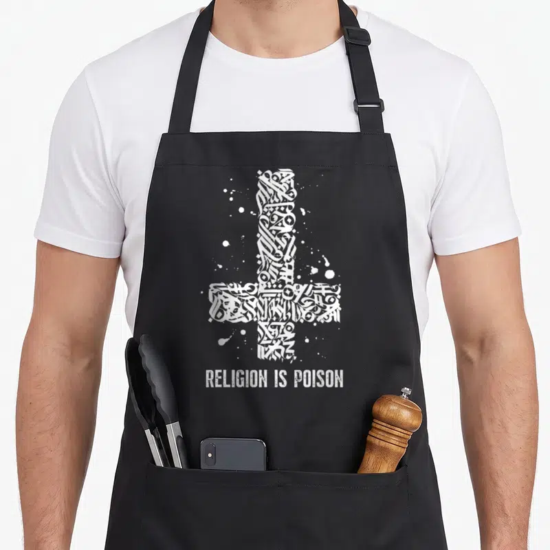 Tablier de cuisine noir avec une croix blanche stylisée et l'inscription Religion Is Poison en bas.