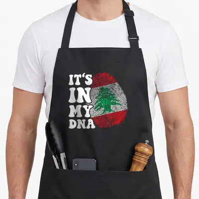 Tablier de cuisine noir avec inscription blanche Drôle c'est dans mon ADN et empreinte digitale aux couleurs du drapeau du Liban.