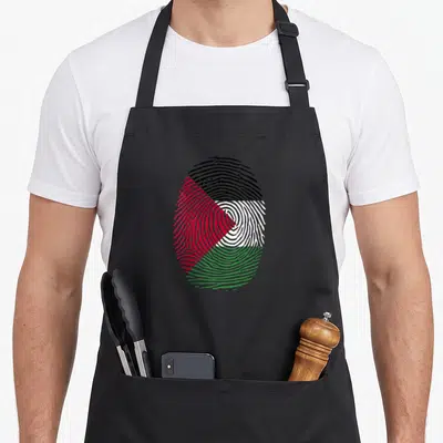 Tablier de cuisine noir avec une grande empreinte digitale aux couleurs du drapeau palestinien, noir, blanc, vert et rouge.