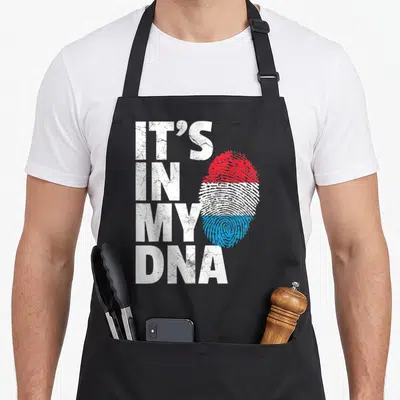 Tablier de cuisine noir avec l'inscription It's in my DNA et une empreinte digitale tricolore rouge blanche et bleue.