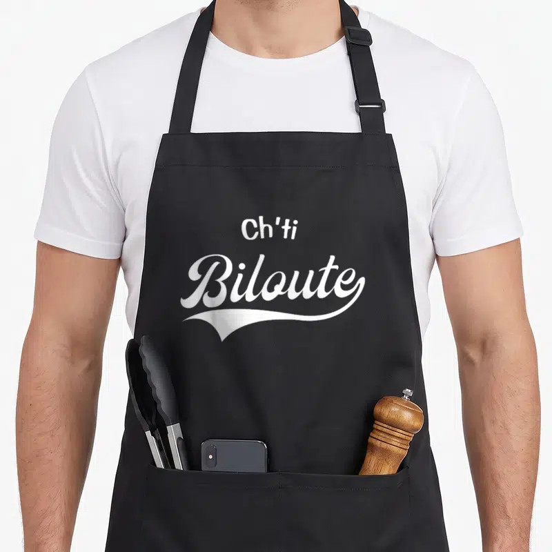 Tablier de cuisine noir avec l'inscription Ch'ti Biloute en lettres blanches stylisées sur le devant.