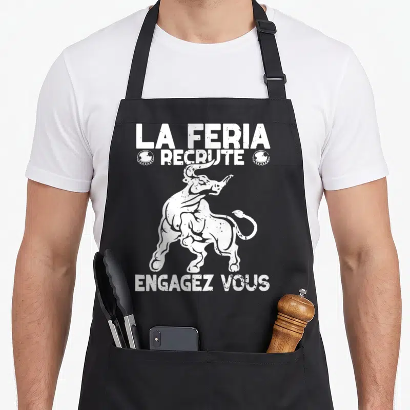 Tablier de cuisine noir avec illustration blanche d'un taureau et texte La Feria recrute Engagez vous.