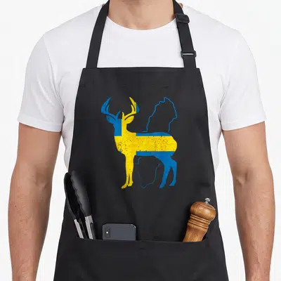 Tablier de cuisine noir avec un cerf aux couleurs du drapeau suédois et des textes sur le thème scandinave