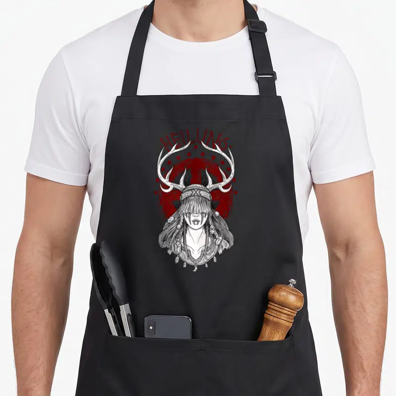 Tablier de cuisine noir avec illustration Shaman Girl Heilung aux antennes et texte rouge.
