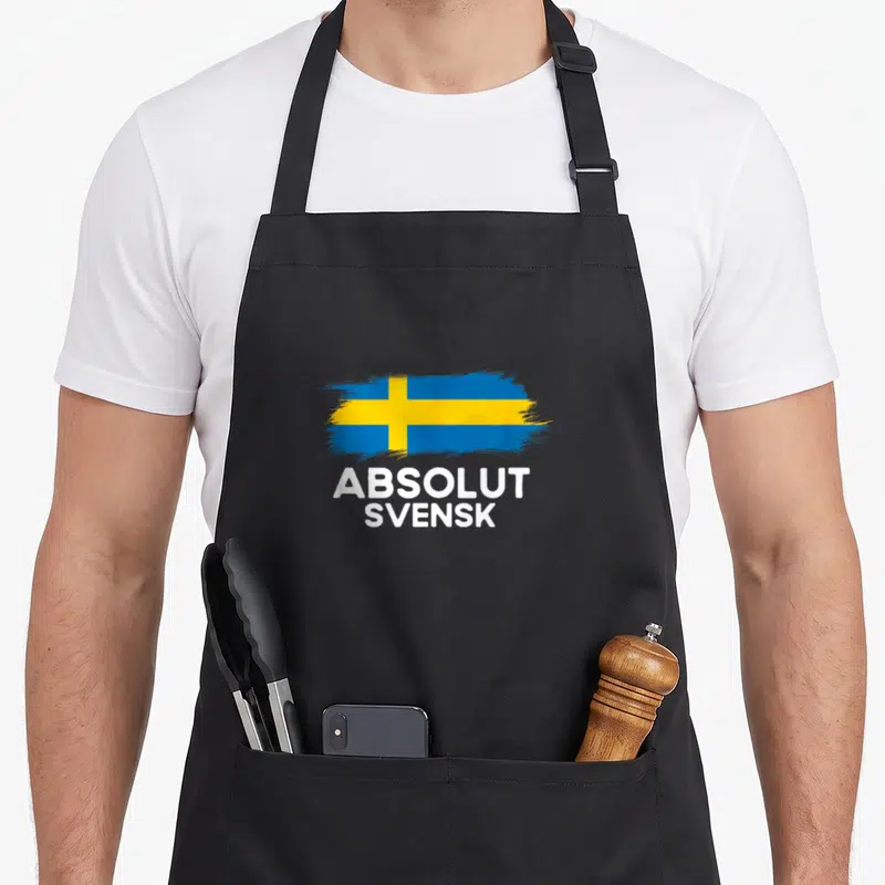 Tablier de cuisine noir avec drapeau suédois bleu et jaune et texte blanc Absolut Svensk