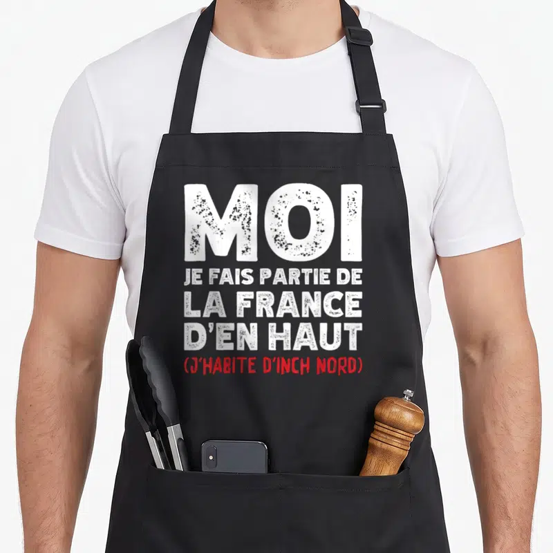Tablier de cuisine noir avec l'inscription Moi je fais partie de la France d'en Haut j'habite d'Inch Nord en blanc et rouge.