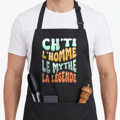 Tablier de cuisine noir avec les mots Ch'ti l'Homme le Mythe la Légende en typographie bulbeuse multicolore.