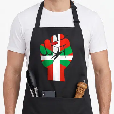 Tablier de cuisine noir avec un poing fermé aux couleurs du drapeau basque rouge, vert et blanc.