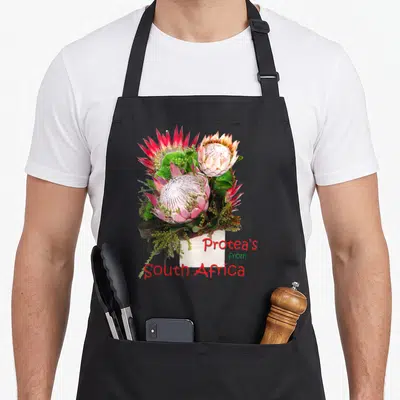 Tablier de cuisine noir avec un bouquet de Protea's from South Africa aux teintes roses et vertes vives.