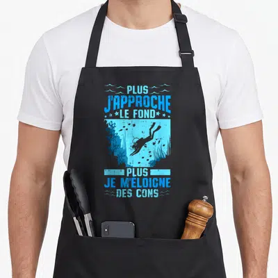 Tablier de cuisine noir avec une illustration de plongeur et un texte humoristique en bleu sur fond aquatique.
