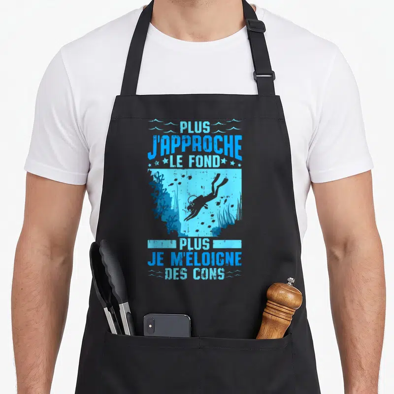 Tablier de cuisine noir avec une illustration de plongeur et un texte humoristique en bleu sur fond aquatique.