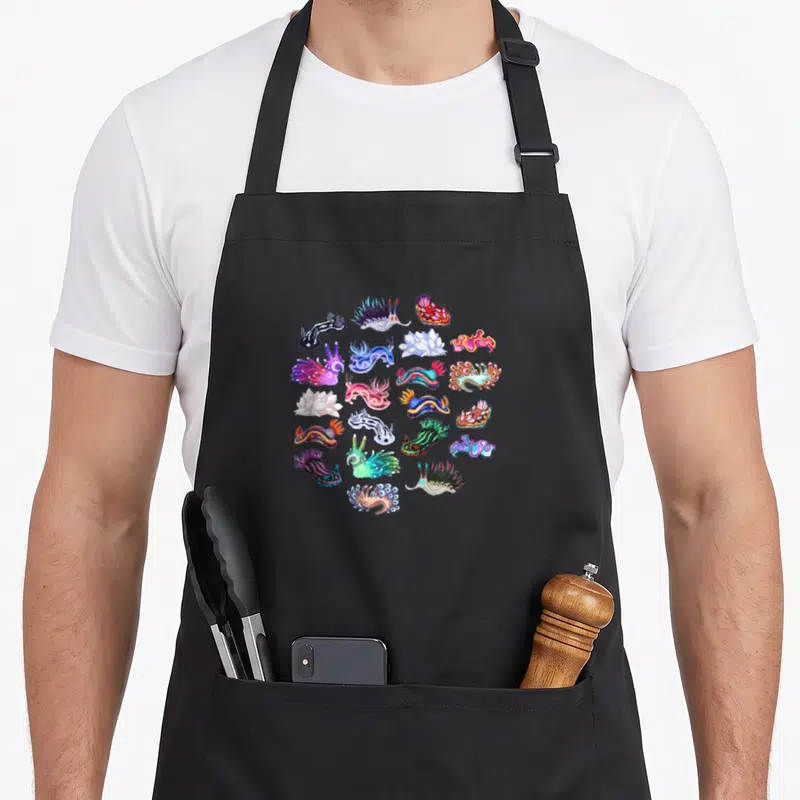 Tablier de cuisine noir avec une illustration groupant de nombreux nudibranches multicolores et des formes marines stylisées.