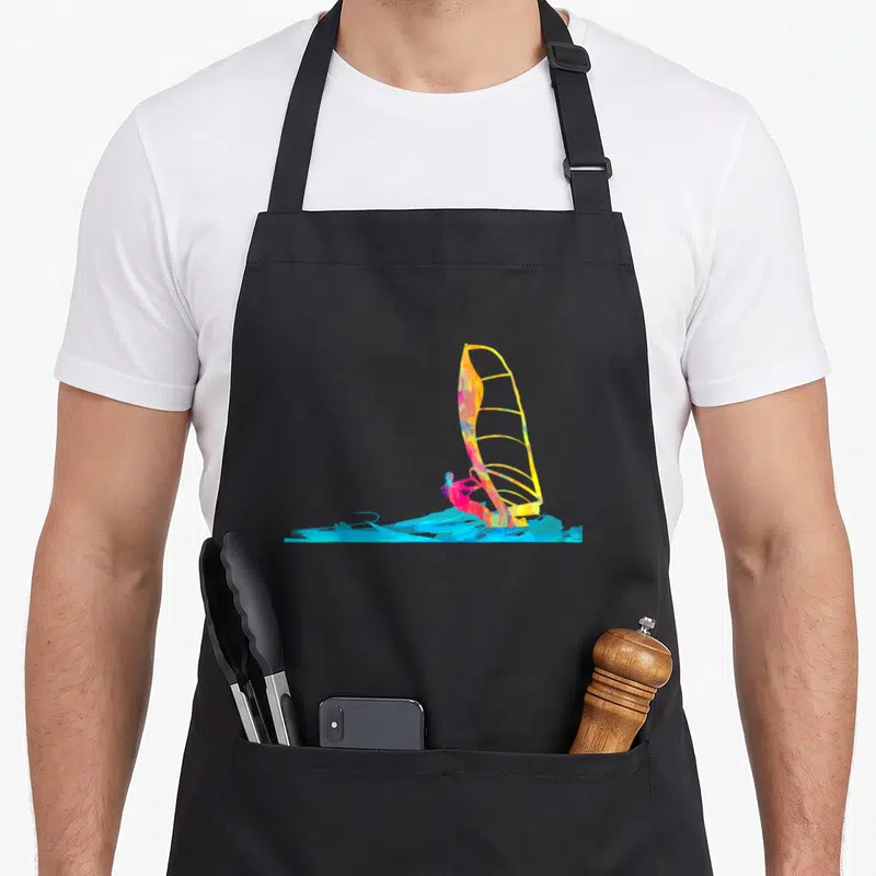 Tablier de cuisine noir avec une illustration colorée d'une planche à voile sur fond bleu vif.