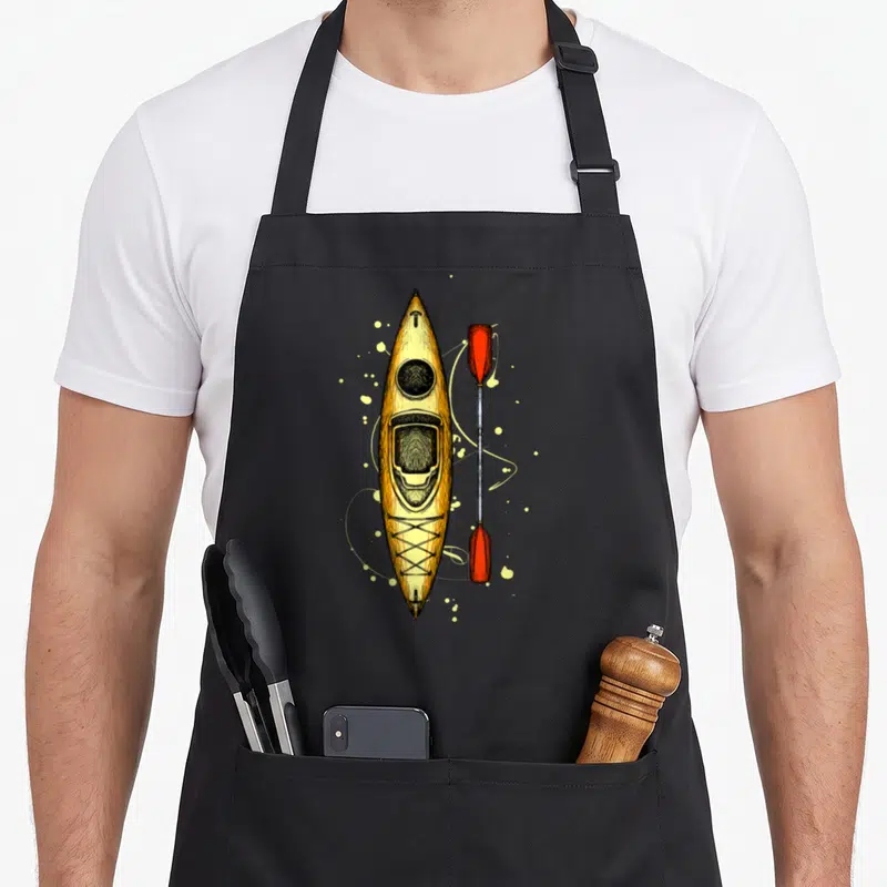 Tablier de cuisine noir avec illustration d'un kayak jaune et d'une pagaie rouge aux lames orange.