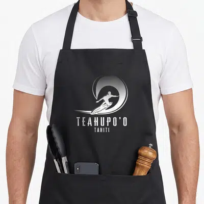Tablier de cuisine noir avec une silhouette de surfeur et le texte Teahupo'o Tahiti en blanc.