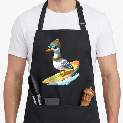 Tablier de cuisine noir avec une mouette surfeuse portant un bonnet tricoté et des lunettes de soleil bleues.