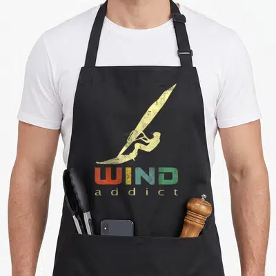 Tablier de cuisine noir avec illustration vintage d'un windsurfeur et le texte WIND addict en couleurs dégradées.