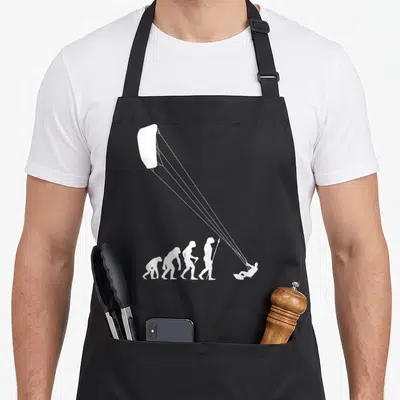 Tablier de cuisine noir avec silhouette évolutive terminant par un kitesurfeur sous voile.