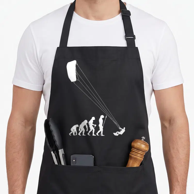 Tablier de cuisine noir avec silhouette évolutive terminant par un kitesurfeur sous voile.